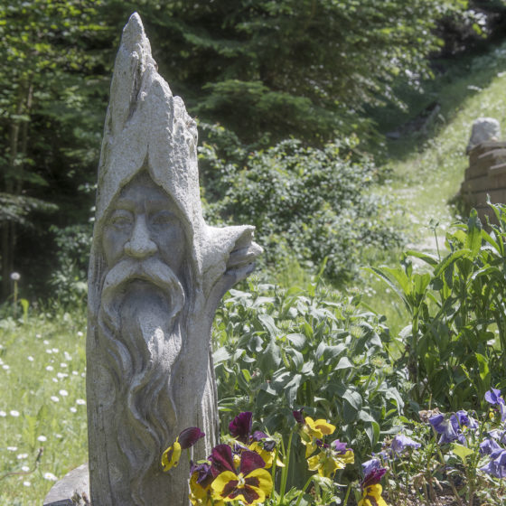 Statue gnome dans le jardin avec fleurs
